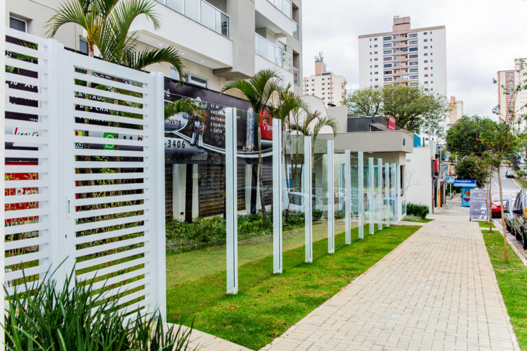 Foto do muo de vidro e alumínio, logo atrás o Pet place e logo em seguida a portaria do prédio